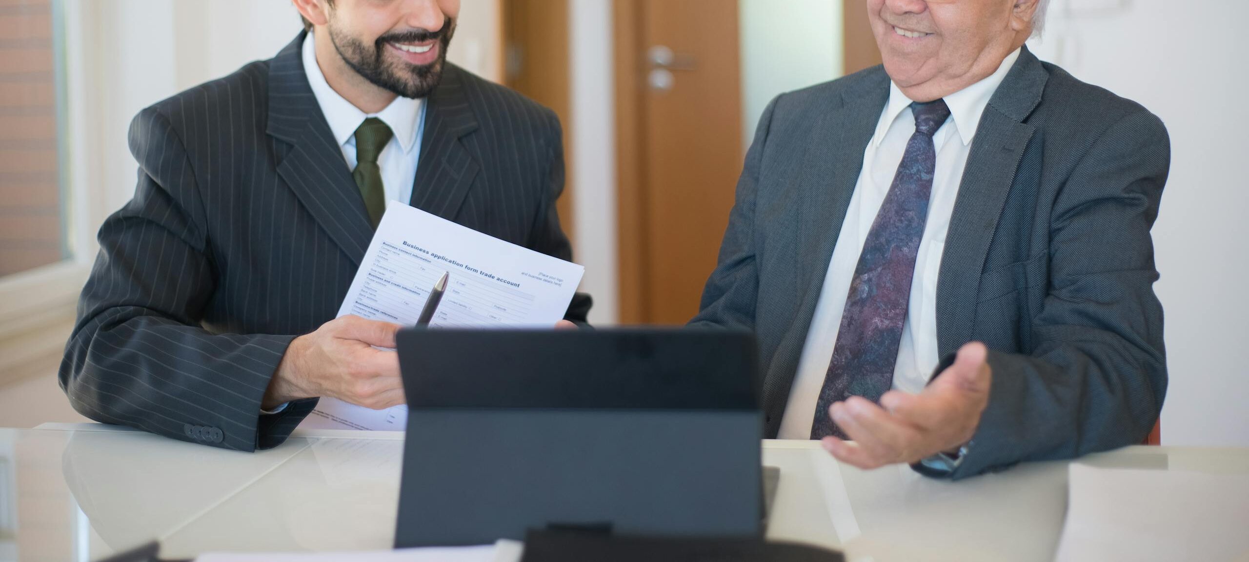 Attorney and client smiling while reviewing settlement paperwork for a mass tort law firm case