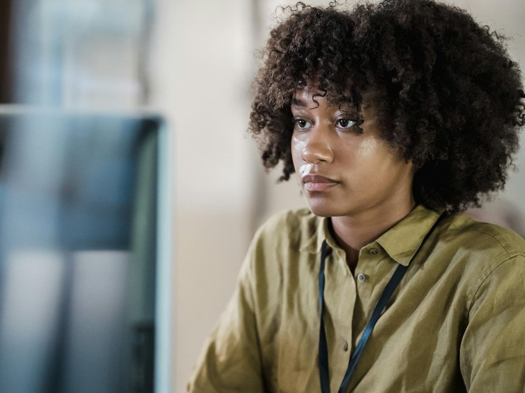 Black woman sitting at desk researching health risks related to hair relaxer use and potential lawsuits