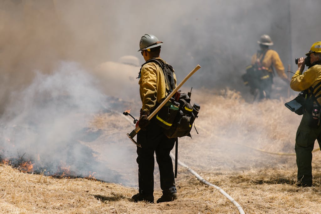 Firefighters battling flames and smoke during a disaster related to nationwide wildfire lawsuits