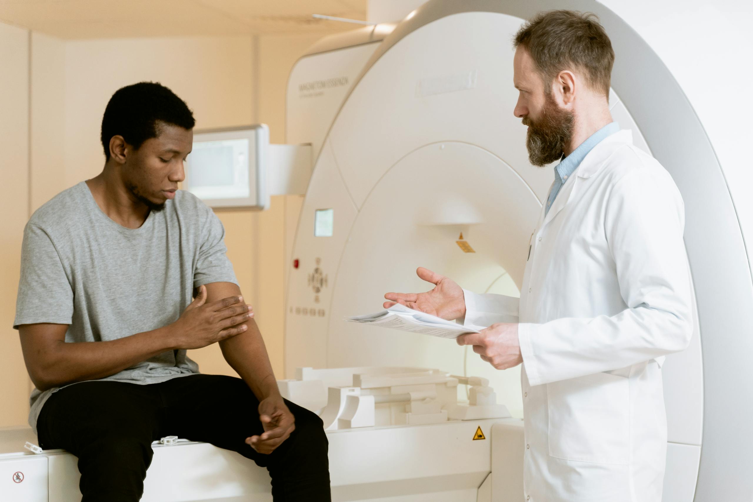 Patient consulting with doctor beside MRI machine in a case related to gadolinium exposure lawsuit